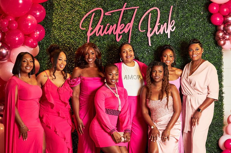 The founder, Ann-Marie Swatson, and attendees taking a picture at a Painted Pink event.
